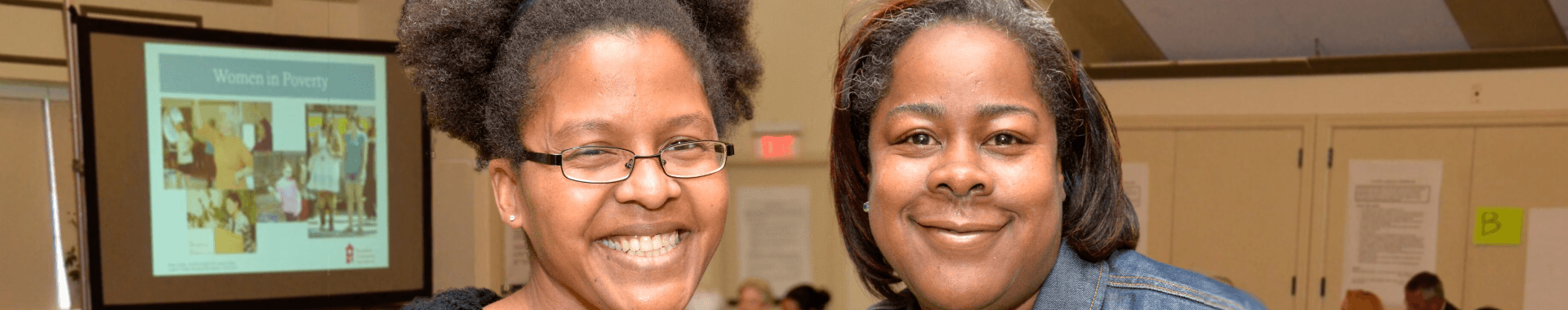 Two women stand next to each other and smile at the camera