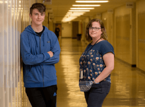student and teacher smiling in school hallway