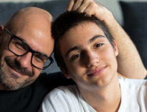 Father and son sitting together smiling.