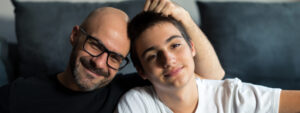 Father and son sitting together smiling.